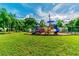 Community playground with slides and swings surrounded by lush greenery, perfect for Gathering fun and outdoor activities at 2692 Cedarbrooke Dr, Palm Harbor, FL 34684