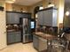 Modern kitchen with gray cabinets, stainless steel appliances, granite countertops, and tile flooring at 2810 Ravendale Ln, Holiday, FL 34691