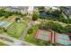 Aerial view highlighting community amenities like tennis, shuffleboard courts, pond, and surrounding buildings at 304 Fowling Ct # A, Sun City Center, FL 33573