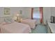 Bedroom featuring twin beds with pink quilts, floral pillows and window view at 304 Fowling Ct # A, Sun City Center, FL 33573