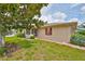 A single-story home with tan siding, red shutters, and a lush green lawn with shade tree at 304 Fowling Ct # A, Sun City Center, FL 33573