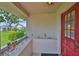 Covered front porch with a red door, textured walls, and a view of a well-kept lawn at 304 Fowling Ct # A, Sun City Center, FL 33573