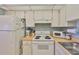 A well-organized kitchen featuring white appliances and functional layout for easy meal preparation at 304 Fowling Ct # A, Sun City Center, FL 33573
