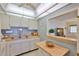 Functional kitchen featuring white cabinets and a breakfast bar area, perfect for casual dining at 304 Fowling Ct # A, Sun City Center, FL 33573