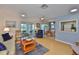 Bright living room with an open layout, ceiling fan, wood-look floors, and access to a screened lanai at 304 Fowling Ct # A, Sun City Center, FL 33573