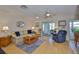 Comfortable living room featuring a ceiling fan, wood flooring, and access to a screened-in patio at 304 Fowling Ct # A, Sun City Center, FL 33573