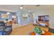 Open concept living room showcasing wood-look floors, modern lighting, and a view into the dining area at 304 Fowling Ct # A, Sun City Center, FL 33573