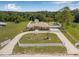 Stunning aerial view of the property showcasing a well-manicured lawn, fenced yard, and circular driveway at 30703 San An Rd, San Antonio, FL 33576