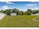 Expansive backyard with green lawn, a metal outbuilding, and a white fence enclosing the property at 30703 San An Rd, San Antonio, FL 33576