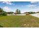 Spacious backyard with lush green lawn, outbuilding, and white fencing, providing a private outdoor space at 30703 San An Rd, San Antonio, FL 33576