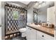 Modern bathroom featuring a unique black, white, and gray patterned tile shower and vanity with a brown countertop at 30703 San An Rd, San Antonio, FL 33576