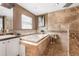 Bathroom with soaking tub and walk-in shower featuring travertine tile at 30703 San An Rd, San Antonio, FL 33576