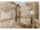 Walk in shower with dual shower heads and travertine tile at 30703 San An Rd, San Antonio, FL 33576