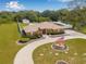 Stunning home with a beautiful water fountain, long driveway, and meticulously manicured landscaping at 30703 San An Rd, San Antonio, FL 33576