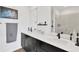 Modern bathroom featuring dual sinks, black fixtures, a large mirror, and walk-in shower at 3100 W Paul Ave # 14, Tampa, FL 33611