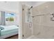 Modern shower in the bathroom with a seamless glass door, white tile, and upscale fixtures, with bedroom view at 3100 W Paul Ave # 14, Tampa, FL 33611