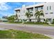Modern townhome with a white exterior, tropical landscaping, and street view at 3100 W Paul Ave # 14, Tampa, FL 33611