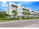 Modern townhome with a white exterior, lined with palm trees and well-maintained landscaping at 3100 W Paul Ave # 14, Tampa, FL 33611