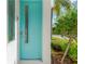 Stylish turquoise front door adds a pop of color, framed by lush landscaping and a modern aesthetic at 3100 W Paul Ave # 14, Tampa, FL 33611