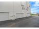 Exterior shot showing multiple garages, painted bright white, with an asphalt parking area at 3100 W Paul Ave # 14, Tampa, FL 33611