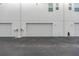 Exterior shot showing multiple garages, painted bright white, in a row with asphalt parking area at 3100 W Paul Ave # 14, Tampa, FL 33611