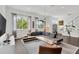 Spacious living room with a comfortable gray sectional sofa, stylish rug, and ample natural light from the large windows at 3100 W Paul Ave # 14, Tampa, FL 33611