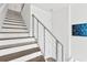 Modern staircase featuring wooden treads, white risers, and minimalist railing, with natural light, ascending at 3100 W Paul Ave # 14, Tampa, FL 33611