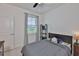 Cozy bedroom with a ceiling fan, dresser, and a window that provides a view of the neighborhood at 314 Blackrock Ln, Apollo Beach, FL 33572