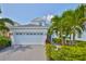 Charming two-story home with a brick driveway, a two-car garage and lush tropical landscaping at 314 Blackrock Ln, Apollo Beach, FL 33572