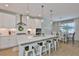 Contemporary white kitchen featuring stainless hood, quartz countertops, and pendant lights at 314 Blackrock Ln, Apollo Beach, FL 33572