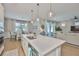 Bright, open kitchen features quartz counters, stainless sink, and modern pendant lighting at 314 Blackrock Ln, Apollo Beach, FL 33572
