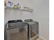 Efficient laundry room with modern washer and dryer, plus shelving for storage at 314 Blackrock Ln, Apollo Beach, FL 33572