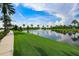 Scenic view of a pond with a fountain, surrounded by lush green grass and palm trees at 314 Blackrock Ln, Apollo Beach, FL 33572