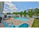 Inviting backyard pool area with beautiful brick pavers, tropical landscaping, and comfortable lounge furniture at 314 Blackrock Ln, Apollo Beach, FL 33572
