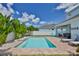 Backyard swimming pool with brick pavers, tropical foliage, and proximity to a covered seating area at 314 Blackrock Ln, Apollo Beach, FL 33572
