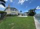 Back exterior view of the home featuring an outdoor pool, green grass, and waterfront access at 413 Midway Is, Clearwater Beach, FL 33767