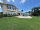 Back exterior view of the home featuring an outdoor pool, green grass, and waterfront access at 413 Midway Is, Clearwater Beach, FL 33767