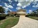 Inviting two-story home with a driveway, lush lawn, and mature landscaping at 413 Midway Is, Clearwater Beach, FL 33767