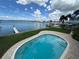 Outdoor pool, dock, and boat on the Intracoastal waterway surrounded by well-kept lawn at 413 Midway Is, Clearwater Beach, FL 33767