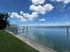 Calm waterfront view showing the intracoastal waterway with a dock, blue skies, and fluffy white clouds at 413 Midway Is, Clearwater Beach, FL 33767