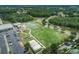 Aerial view showcasing the community park and recreation area, including tennis courts, playground, and expansive green space at 4222 Glade Wood Loop, New Port Richey, FL 34655