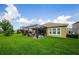 Spacious backyard with lush lawn, covered patio, screened in area, and beautiful landscaping at 4222 Glade Wood Loop, New Port Richey, FL 34655