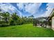 Expansive green backyard featuring a screened-in patio area for enjoyable outdoor living at 4222 Glade Wood Loop, New Port Richey, FL 34655