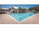 The community pool area features both a full-sized pool and a jacuzzi, alongside a pool house and shaded lounge areas at 4222 Glade Wood Loop, New Port Richey, FL 34655