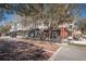 Street view of modern multi-story building with ground-floor retail spaces and outdoor seating at 4222 Glade Wood Loop, New Port Richey, FL 34655