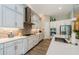 Modern kitchen features stainless steel appliances, white cabinets, tile backsplash and wood flooring at 4222 Glade Wood Loop, New Port Richey, FL 34655