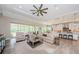 Open-concept living room with a large ceiling fan, kitchen, and screened patio access at 4222 Glade Wood Loop, New Port Richey, FL 34655
