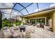 Screened-in patio with ample seating, a fire pit, and tranquil fountain features for ultimate relaxation at 4222 Glade Wood Loop, New Port Richey, FL 34655
