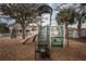 Community playground with a slide and climbing area surrounded by trees at 4222 Glade Wood Loop, New Port Richey, FL 34655