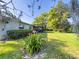 Landscaped backyard with a screened-in porch and flowering plants at 4404 Hickory Branch Ct, Brandon, FL 33511